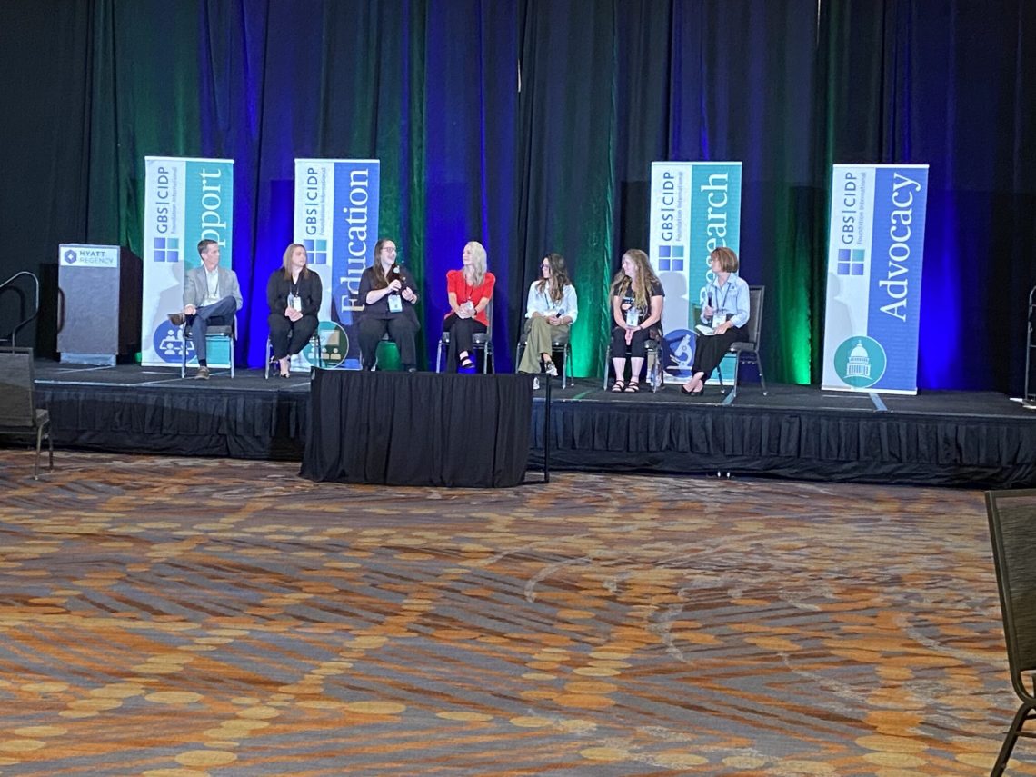 group of people sitting on the stage talking