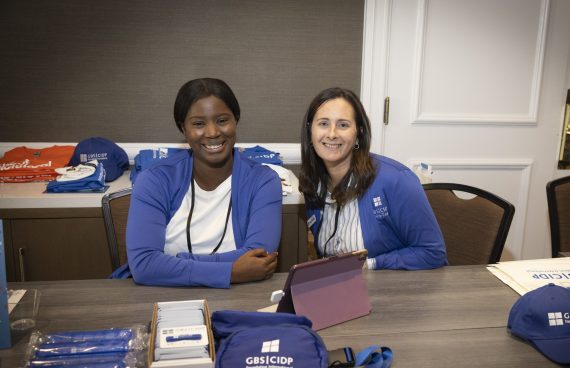 Two volunteers sit at a table