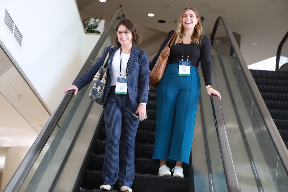 two women descend an escalator